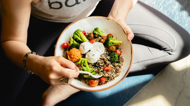Bowl con quinoa, broccoli, pomodorini e mozzarella, esempio di pasto sano ed equilibrato.
