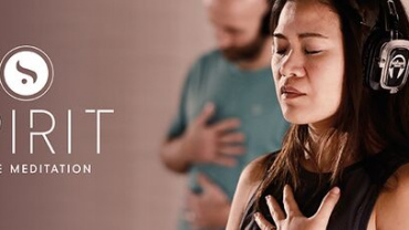 Partecipante alla lezione SPIRIT Dance Meditation con cuffie, durante un momento di meditazione.
