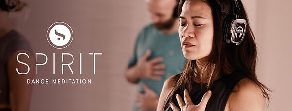 Partecipante alla lezione SPIRIT Dance Meditation con cuffie, durante un momento di meditazione.